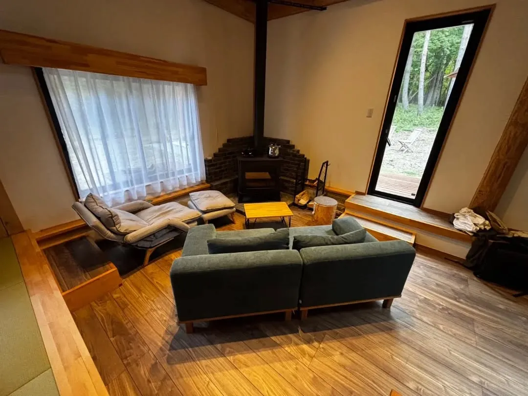 大きな窓から差し込む自然光が、室内の木材をやわらかく照らし、...