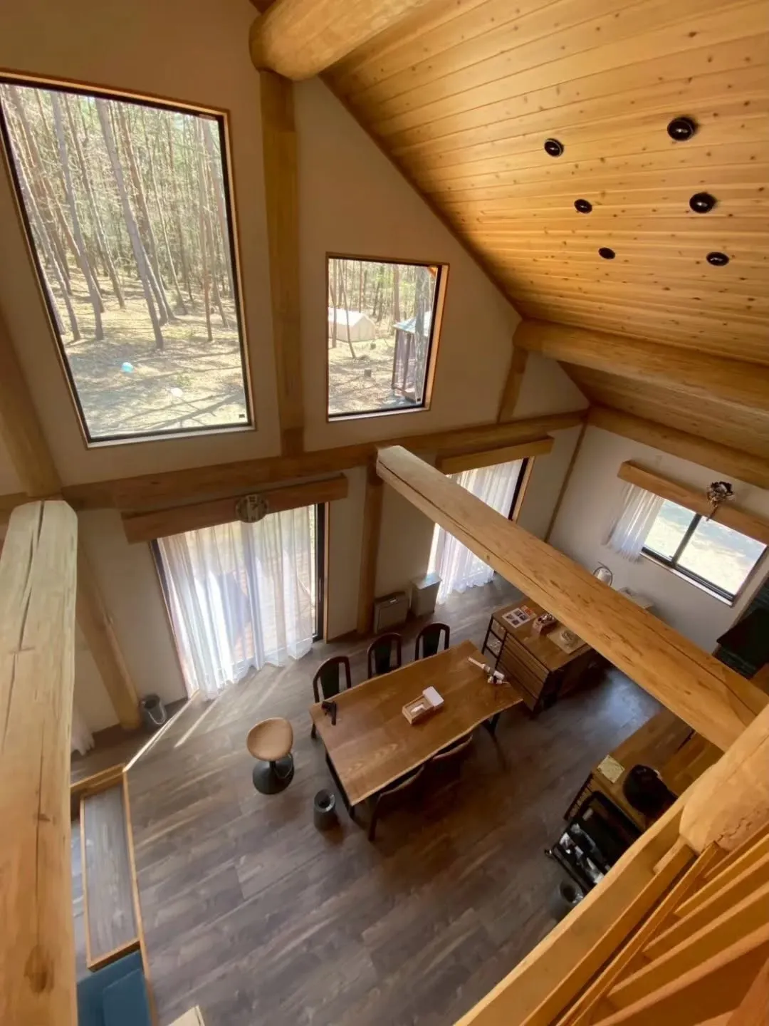 ロフトから見下ろすリビングは、木の温もりと柔らかな光に包まれ...