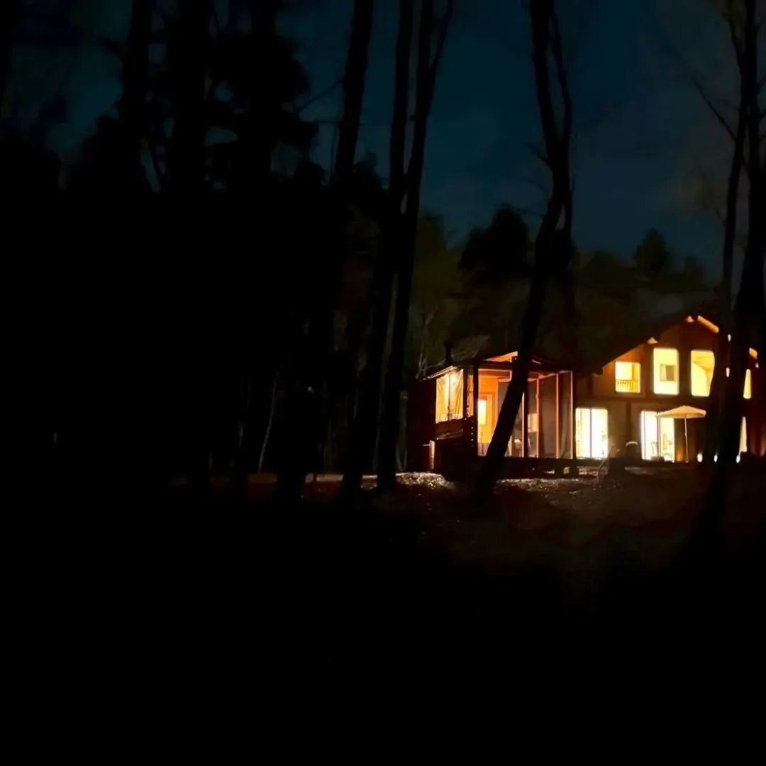 夜の森にそっと灯る明かりが、建物の輪郭をやわらかく浮かび上が...